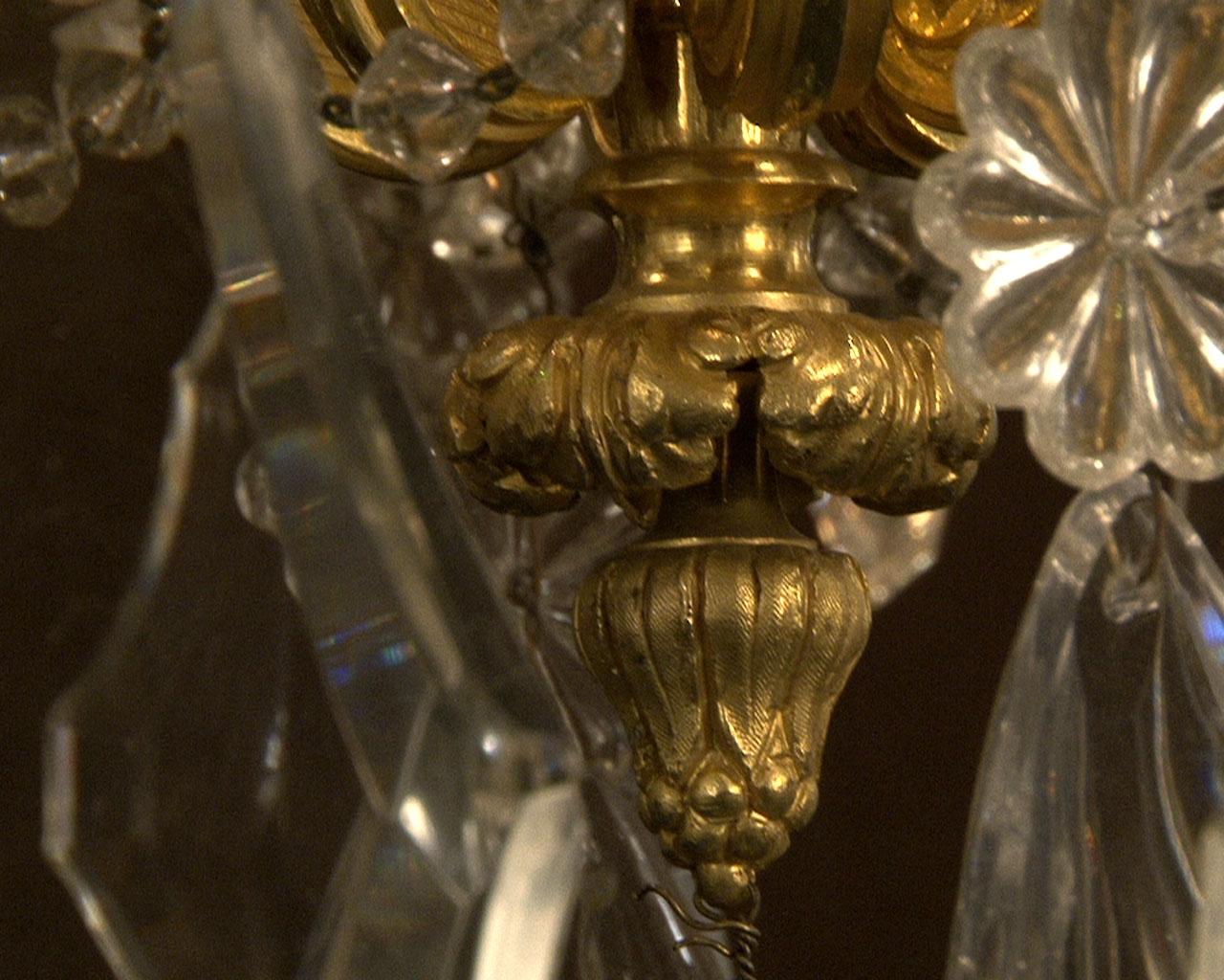 Lustre à cristaux à 12 bras et 18 lumières , décors de passementeries en bronze doré.-18