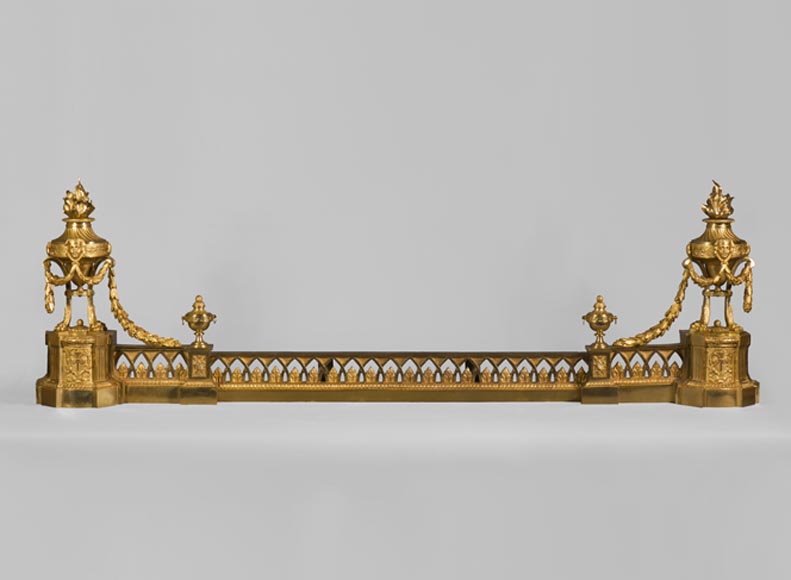 Barre de chenets ancienne de style Louis XVI à décor d'urnes enflammées en bronze doré-0