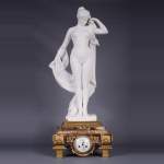 Pendule en marbre fleur de pêcher et bronze doré surmontée d’une sculpture en marbre   blanc statuaire représentant Phryné devant ses juges, signée « Campagne », vers 1900