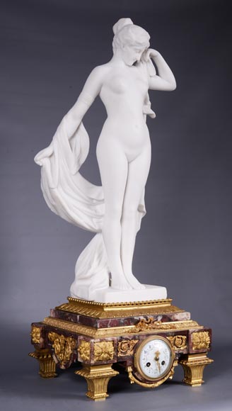 Pendule en marbre fleur de pêcher et bronze doré surmontée d’une sculpture en marbre   blanc statuaire représentant Phryné devant ses juges, signée « Campagne », vers 1900-1