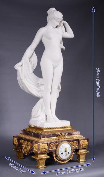 Pendule en marbre fleur de pêcher et bronze doré surmontée d’une sculpture en marbre   blanc statuaire représentant Phryné devant ses juges, signée « Campagne », vers 1900-14