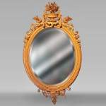 Miroir ovale en bois doré de style Louis XV au vase fleuri