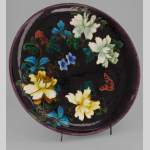 Théodore Deck - Plat circulaire à décor de fleurs et papillon sur fond aubergine