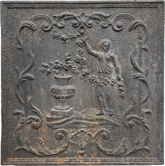 Plaque de cheminée du XVIIIe siècle représentant une figure féminine à la guirlande de fleur à côté d’un vase antique-0