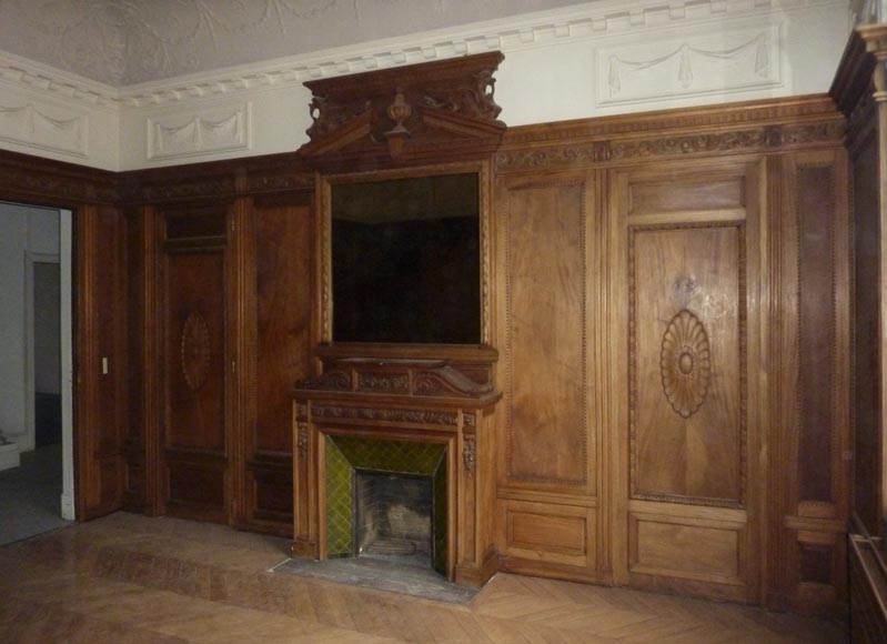 Pièce de boiserie de style Napoléon III avec cheminée à miroir et décor de chimères en bois sculpté -0