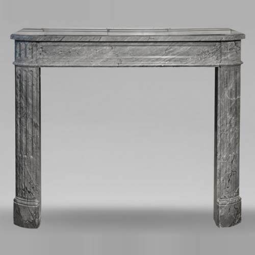 Cheminée de style Louis XVI en marbre bleu turquin, aux pieds cannelés