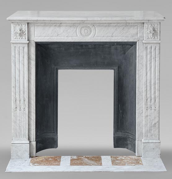 Cheminée de style Louis XVI en marbre de Carrare ornée de tournesols et à pieds cannelés-0