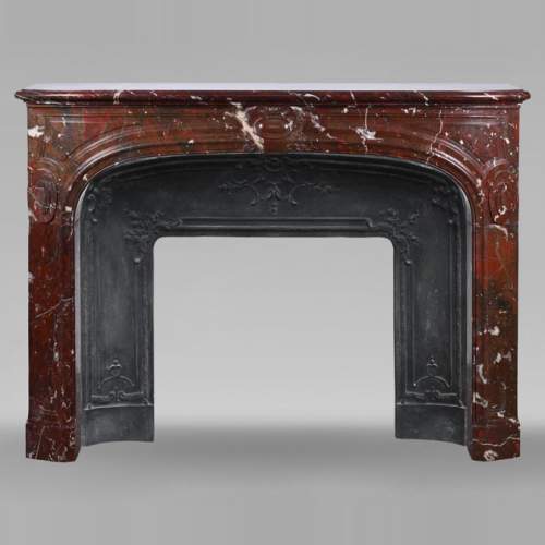 Cheminée de style Régence sculptée en marbre rouge griotte
