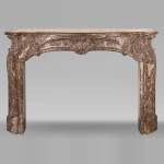Cheminée d'époque Louis XV ornée d'une palmette asymétrique dans une variation de marbre Rouge Royal