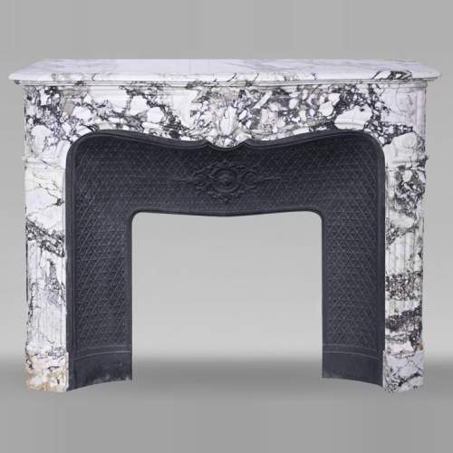 Cheminée de style Régence en brèche violette, décorée d'une grosse coquille