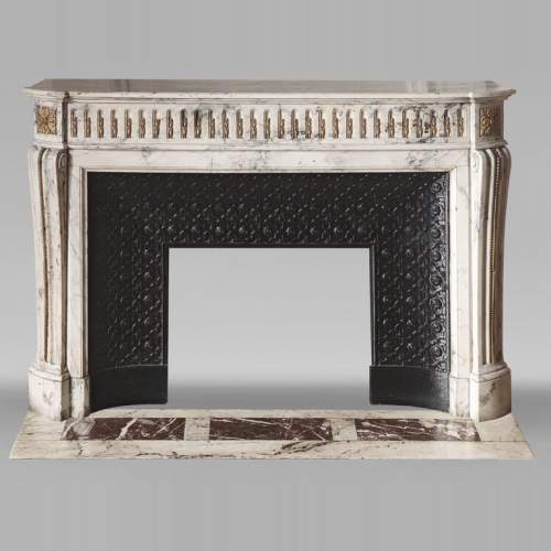 Cheminée galbée de style Louis XVI en marbre veiné, à décor d'asperge en bronze