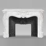 Cheminée de style Louis XV en marbre de Carrare richement sculptée de motifs végétaux