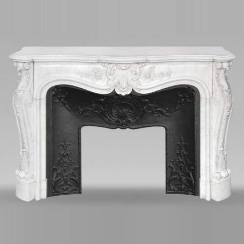Cheminée de style Louis XV en marbre de Carrare richement sculptée de motifs végétaux